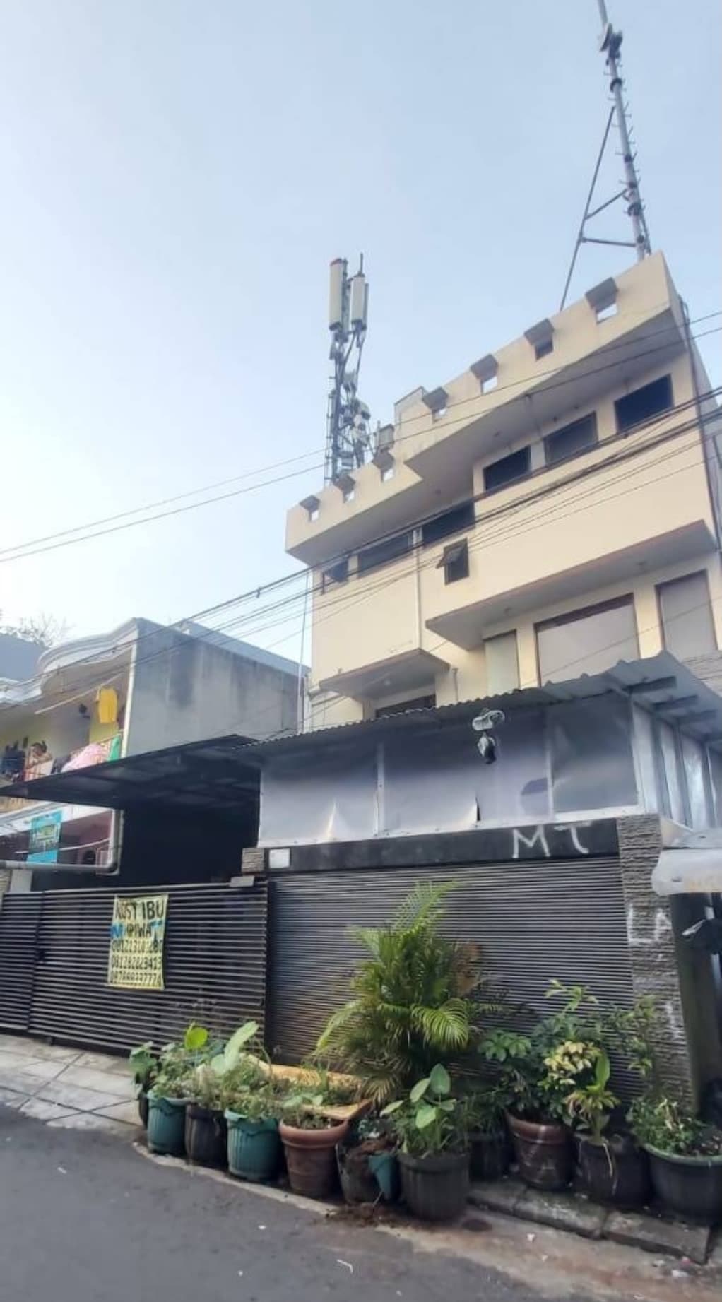 Kost Ibu tampak depan dengan pagar hitam dengan tiga lantai